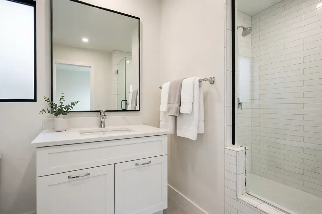 Modern bathroom vanity with chrome faucet, framed mirror and neatly mounted towel bar